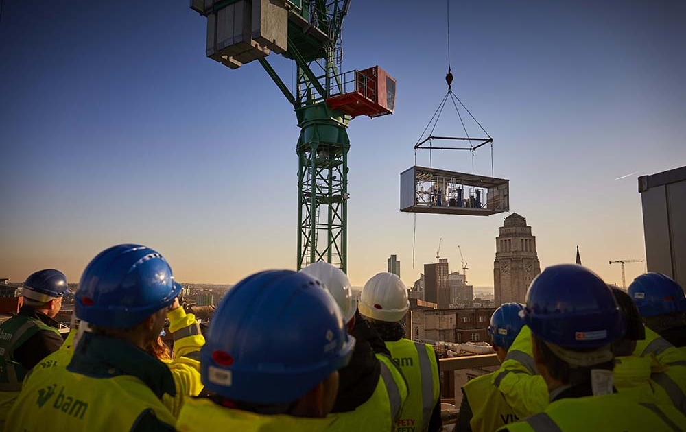 Colleagues watch as the plant room is craned to the roof of the Sir William Henry Bragg Building project