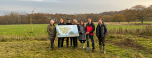 Gair Wood tree planting featuring participants standing next to a map of Gair Wood