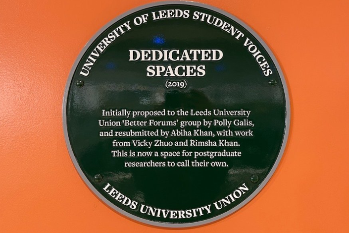 green plaque located at Postgraduate Research Lounge