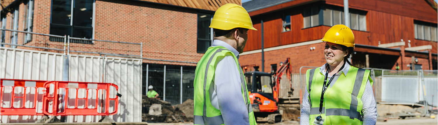 Two colleagues in high vis clothing on a construction site