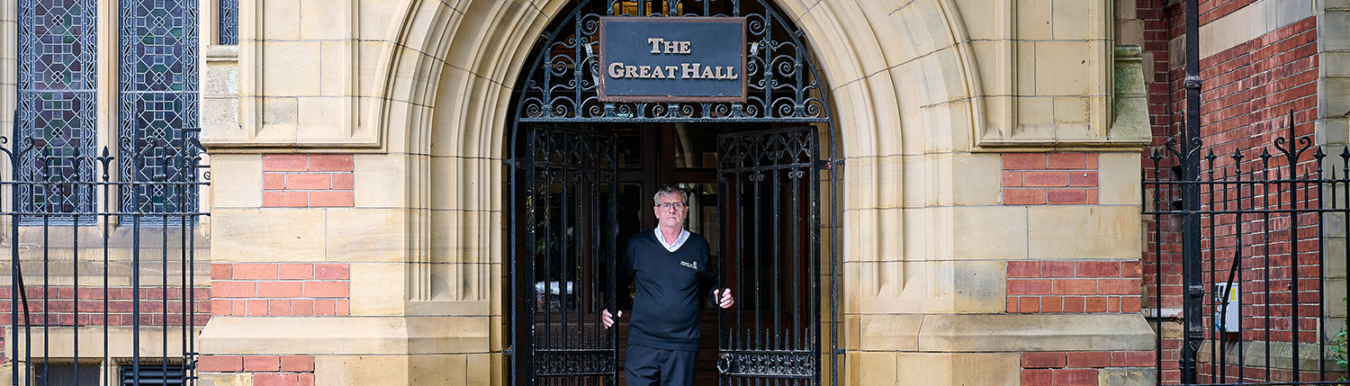 Porter opening the gates to the Great Hall