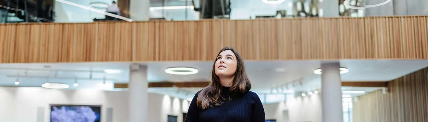 Woman looking up in modern office space