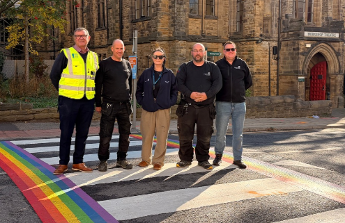 Delivery team on the progress Pride flag crossing outside Michael Sadler Building University Maintenance team alongside contractors Wates standing on the new crossing